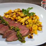 Rosa gebratenes Rindersteak mit Chimichurri und mediterranen Kartoffelwürfeln