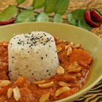 Nigerianischer Erdnusstopf mit Schweinefleisch, Banane und Sesamreis